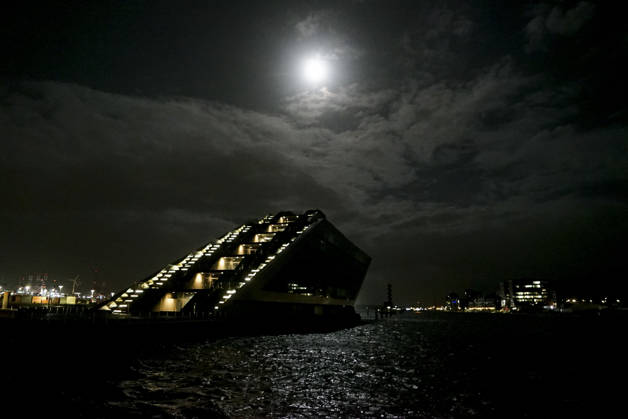 CNTV FLOODING: A hazy full moon in the sky; fall flooding in the Port of Hamburg, the Hamburg Fish Market and the Oevelgoenne parking lot were flooded by the Elbe; in the fish auction hall, the water was about 50 cm deep. Hamburg, October 26, 2026. The combination of the full moon and the storm surge caused the Elbe flooding in Hamburg, Germany.