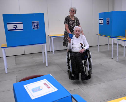 An elderly woman holds her ballot at a polling station for the Israeli general election, in Jerusalem on Tuesday, October 27, 2026.  JER2026102712 DEBBIExHILL