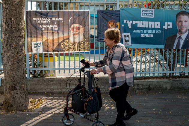 High Turnout in Israeli elections in Israel - 27 Oct 2026 A woman walks past campaign banners for the Shas party and the Religious Zionism party, led by Bezalel Smotrich, hanging on a fence outside a school serving as a polling station. The Shas banner features Rabbi Ovadia Yosef, the party’s founder. Israelis head to the polls to cast their ballots in an election widely seen as one of the most consequential in the country’s history. Voters turned out at 12 p.m. which is the highest recorded time since 1973. Ganey Tikva Israel Copyright: xSharonxEilonx xSOPAxImagesx Sharon_Eilon-357