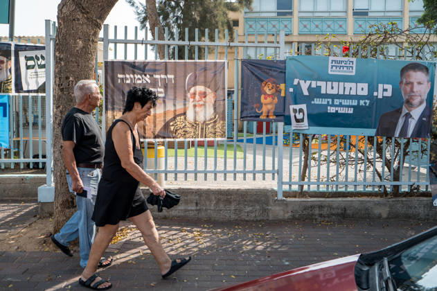 High Turnout in Israeli elections in Israel - 27 Oct 2026 A couple walks past campaign banners for the Shas party and the Religious Zionism party, led by Bezalel Smotrich, hanging on a fence outside a school serving as a polling station. The Shas banner features Rabbi Ovadia Yosef, the party’s founder. Israelis head to the polls to cast their ballots in an election widely seen as one of the most consequential in the country’s history. Voters turned out at 12 p.m. which is the highest recorded time since 1973. Ganey Tikva Israel Copyright: xSharonxEilonx xSOPAxImagesx Sharon_Eilon-355