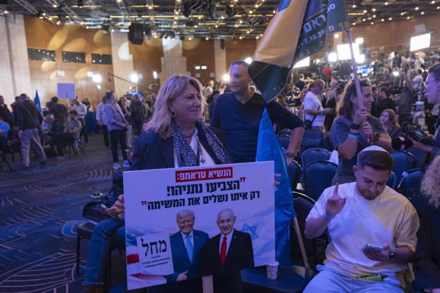 Likud Supporters Await Netanyahu Appearance A woman holds a Likud campaign placard depicting US President Donald Trump alongside Israeli Prime Minister Benjamin Netanyahu at the party headquarters in Tel Aviv, Israel, on October 28, 2026. The Hebrew text attributes to Trump the appeal Vote Netanyahu! Only with him will we complete the mission as party supporters await Netanyahu after television exit polls projected Likud as the largest Knesset party but no clear majority for either political bloc. Tel Aviv Tel Aviv Israel Copyright: xKatrinexDigexHoumollerx