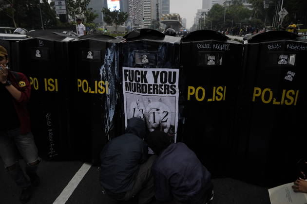 October 28, 2026, Jakarta, Indonesia: Student protesters crouch in front of police riot shields bearing a poster reading Ã¢â‚¬oeFuck You MurderersÃ¢â‚¬Â during a demonstration at Bundaran HI Jakarta Indonesia  - ZUMAm265 20261028_zip_m265_019 Copyright: xAndrixMunazirx