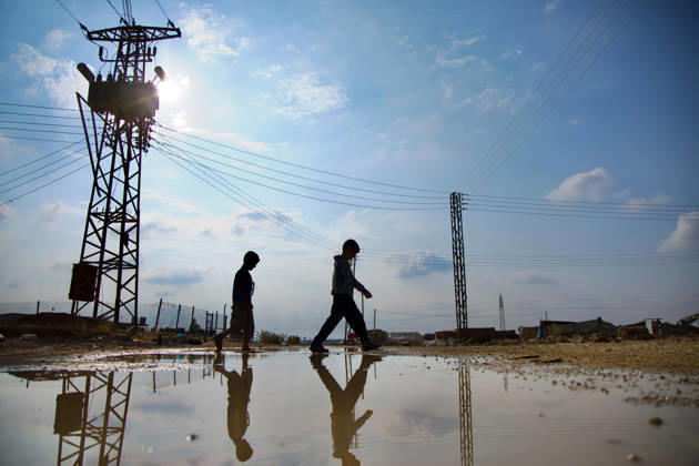 Flooding Damages Al-Talai Displacement Camp Two people walk past a large rainwater puddle reflecting an electrical pole and power lines at Al-Tala i camp in Al-Hasakah, Syria, on October 29, 2026. Heavy rain on October 28-29 flooded tents at Al-Tala i, also known as Serekaniye camp, which shelters families displaced from Ras al-Ain, damaging bedding and belongings and prompting calls for humanitarian assistance. Al á¸¨asakah Al-Hasakah Syria Copyright: xMohammedxMirx