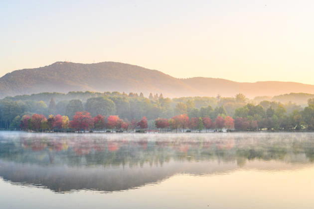 NANJING, CHINA - OCTOBER 31: Trees with colorful foliage and a quiet lake are shrouded in morning mist at the Qianyue Dyke of the Nanjing Botanical Garden on October 31, 2026 in Nanjing, Jiangsu Province of China.  Copyright: xVCGx 111678300610