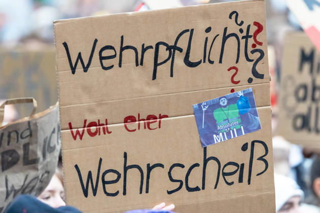 Gen Z Takes Charge: Hundreds March Through the Old Town and Südstadt, Nuremberg, October 31, 2026. At a rally organized by the Gen Z Takes Charge initiative, a protester holds up a cardboard sign reading Conscription, More like military bullshit! The nationwide initiative opposes conscription and austerity measures that burd 20261031-1V9A3957-M4000