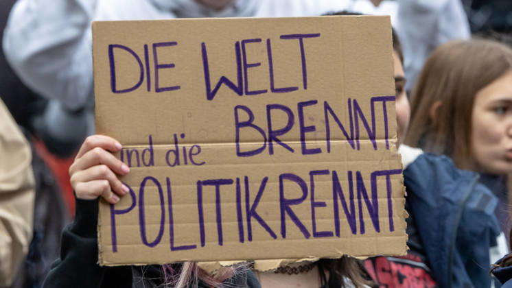 Gen Z Takes Charge: Hundreds March Through the Old Town and Südstadt, Nuremberg, October 31, 2026: At a rally organized by the Gen Z Regelt initiative, a protester holds up a cardboard sign reading The world is on fire and politicians are asleep at the wheel. The nationwide in 20261031-1V9A3937-M4000