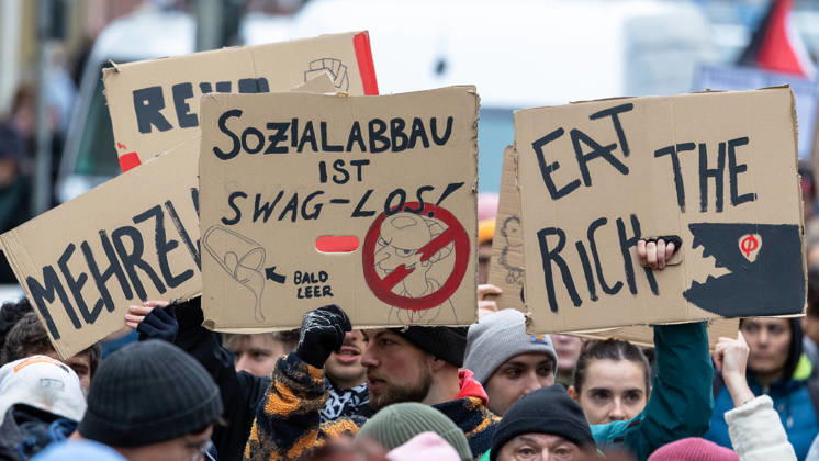 Gen Z Takes Charge: Hundreds March Through the Old Town and Südstadt, Nuremberg, October 31, 2026. Participants in the Gen Z Takes Charge initiative hold up cardboard signs with slogans such as Cutting social services is swag, Eat the Rich! The initiative is calling for n 20261031-1V9A3955-M4000