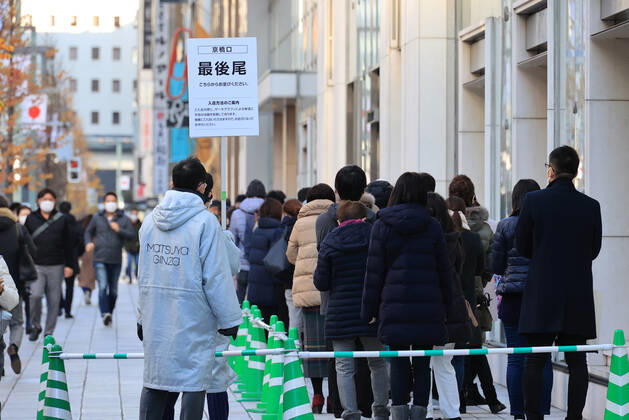 Coronavirus in Japan, Menschen stehen vor einem Kaufhaus in Tokio Schlange