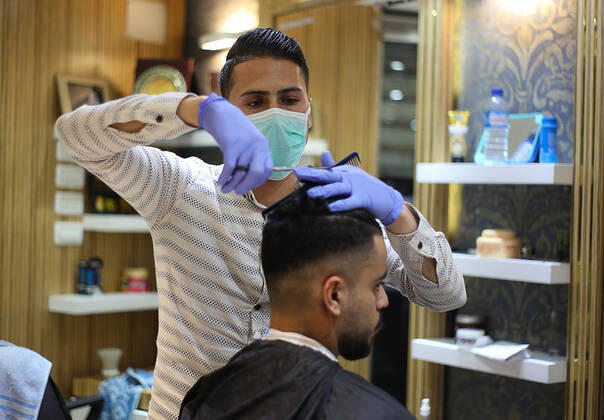 Coronavirus, Barbier bei seiner Arbeit mit Mundschutz in Gaza