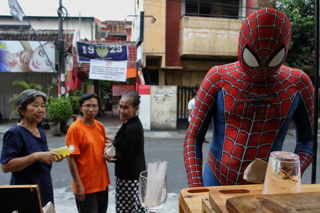 Coronavirus in Indonesien, kostümierter Spiderman bei Essensausgabe in Yogyakarta