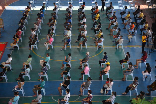 Coronavirus in Thailand, Menschen warten in Bangkok diszipliniert Abstand haltend auf Mönchsgaben